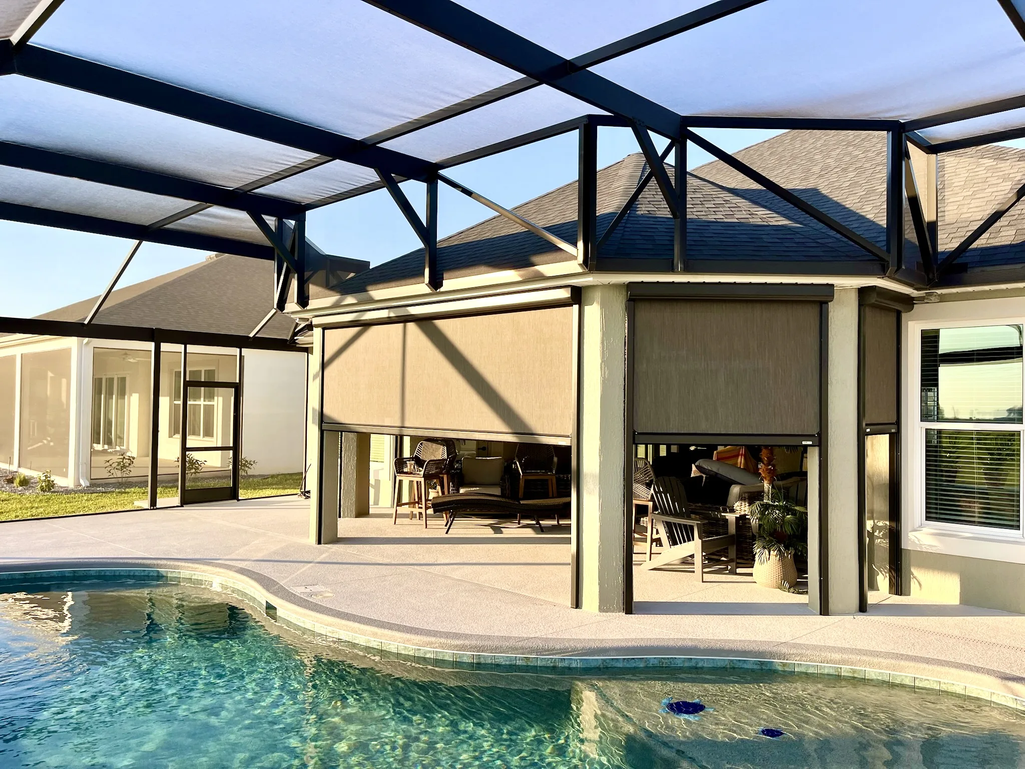 Motorized exterior shade on a screened pool lanai birdcage